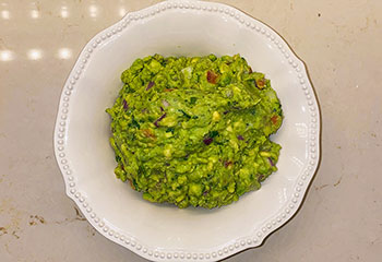 Finished guacamole recipe in a white serving bowl